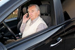 Senior mit Mobiltelefon im Auto
