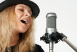 Photo: Young woman singing with studio microphone Young woman singing with studio microphone