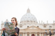 Photo: Pretty young female tourist studying a map at St. Peter's square Pretty young female tourist studying a map at St. Peter's square