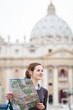 Pretty young female tourist studying a map at St. Peter's square