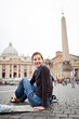 Pretty young female tourist studying a map at St. Peter's square
