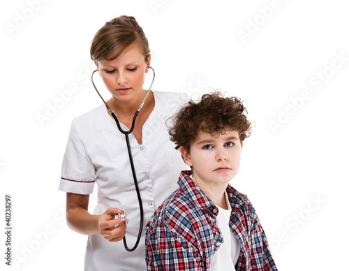 Photo: Doctor examining young boy isolated on white background Doctor examining young boy isolated on white background