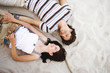 Young couple lying on sand, smiling, overhead view