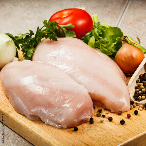 Photo: Raw chicken breasts on cutting board Raw chicken breasts on cutting board