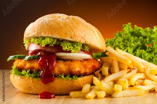 Photo: Big hamburger, French fries and vegetables Big hamburger, French fries and vegetables