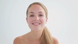 Smiling woman using a cotton wool on her face