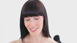 Smiling woman using a powder brush