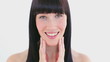 Smiling brunette massaging her two cheeks