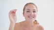 Smiling woman using a pair of tweezers