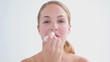 Smiling blonde woman using a lip balm
