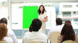 Businesswoman gesturing in front of a board