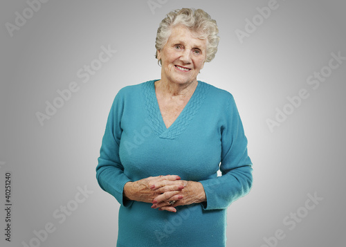 Foto: portrait of senior woman standing over grey background portrait of senior woman standing over grey background