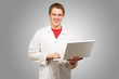 portrait of young student holding laptop over grey background