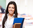 portrait of young woman holding notebook on classroom portrait of young woman holding notebook on classroom