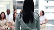 Brunette business woman speaking to business people