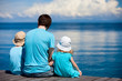 Foto: Father and kids sitting on wooden dock Father and kids sitting on wooden dock