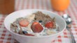 Strawberry falling in super slow motion in cereal bowl