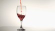 Red wine filling in super slow motion a glass of wine