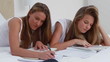 Video: Happy young woman doing her homework with a friend Happy young woman doing her homework with a friend