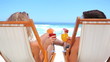 Couple on deck chairs drinking cocktails