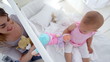 Mother playing with her baby with dolls