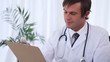 Doctor writing on a clipboard while sitting