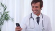 Happy doctor sending a text message