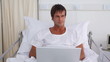 Patient using a laptop while sitting in a sickbed