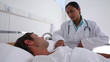 Doctor talking to a patient lies in a bed