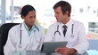 Vídeo: Doctors smiling while using a tablet computer Doctors smiling while using a tablet computer
