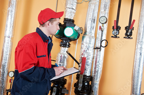 Photo: heating engineer repairman in boiler room heating engineer repairman in boiler room