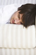 Young man sleeping on bed, smiling