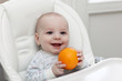 Smiling baby with orange