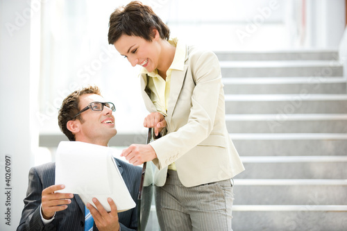 Foto: Business people holding document, smiling Business people holding document, smiling