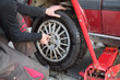 Automotive, mechanic working on a car tire in service Automotive, mechanic working on a car tire in service