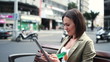 Happy young woman with tablet computer in the city