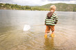 Boy holding fishing net in river