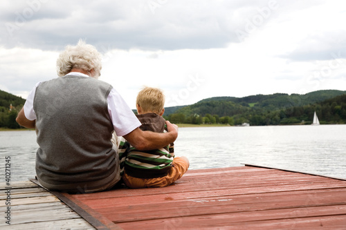 Photo: Grandfather sitting with grandson on pier Grandfather sitting with grandson on pier
