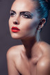 Face of a beautiful woman with creative makeup and red lips