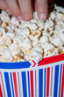 woman's hand picking popcorn bowl
