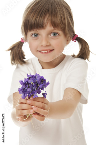 Photo: little girl giving a bouquet of violets little girl giving a bouquet of violets