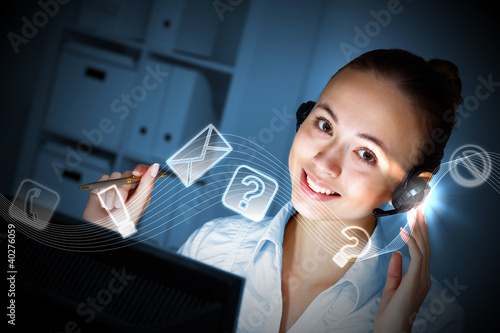 Photo: Young woman in business wear and headset Young woman in business wear and headset