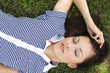 Young woman lying on grass, portrait