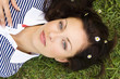 Young woman lying on grass, portrait