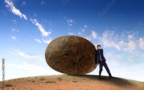Illustration: Businessman rolling a giant stone Businessman rolling a giant stone