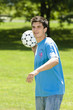 Young man throwing soccer ball in park, portrait