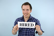 young man holding hired sign