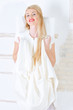 beautiful young woman in white dress posing