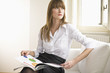 Young woman sitting on sofa, looking away