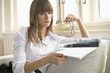 Young woman reading magazine, holding glasses